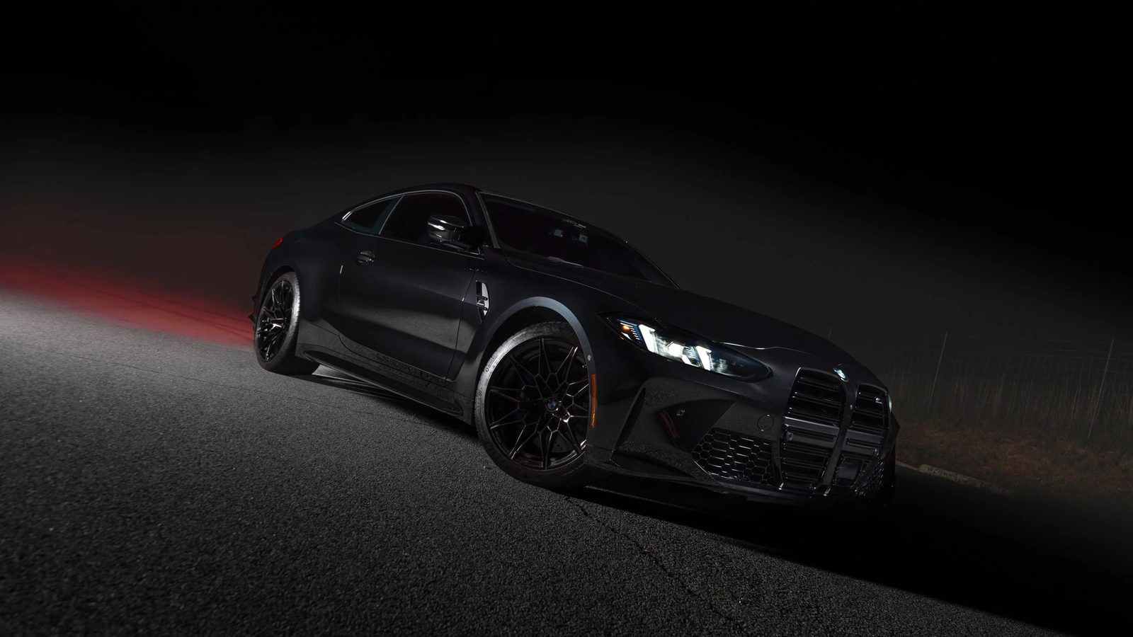 Dark BMW coupe photographed at night with commercial light painting